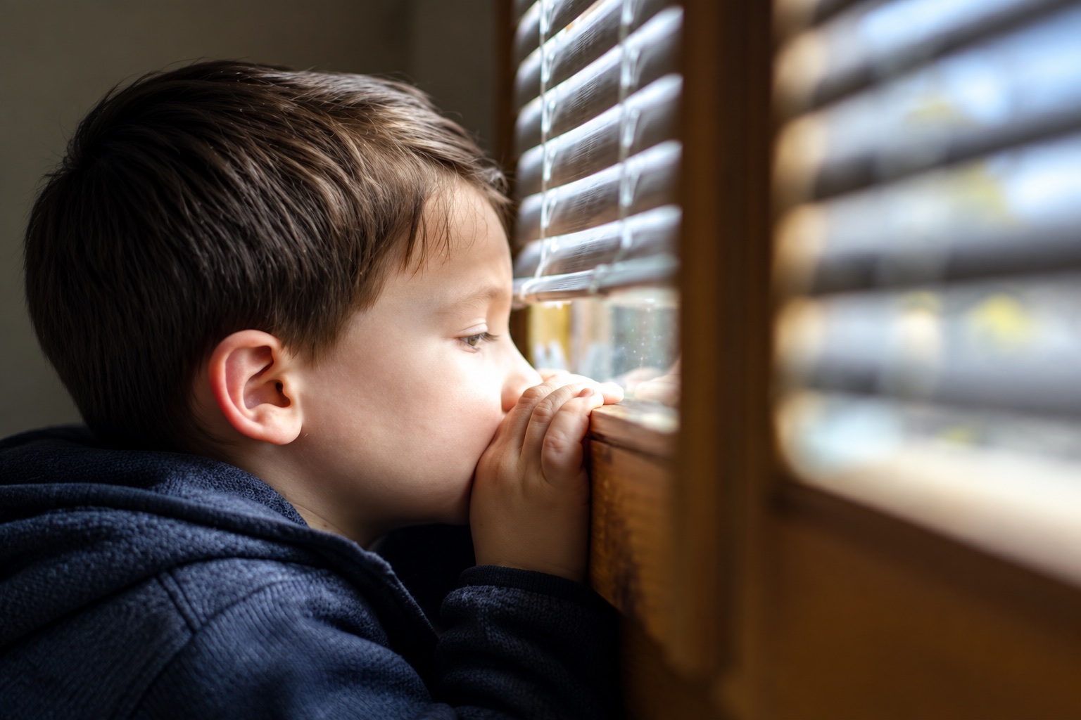 A child looking through a window in natural light.